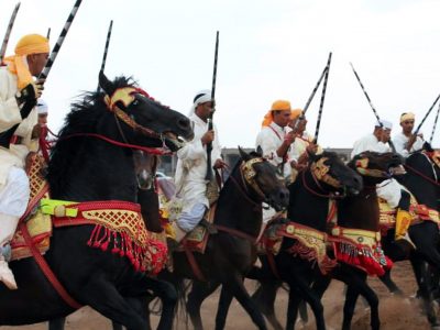 persone a cavallo per manifestazione tbourida a Marrakech