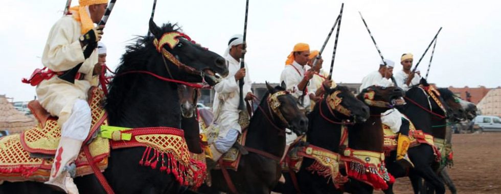 persone a cavallo per manifestazione tbourida a Marrakech